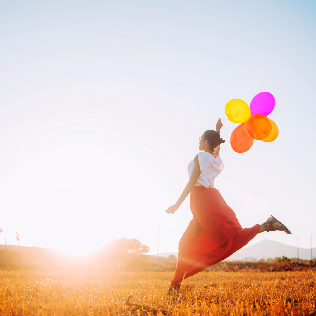 Women jumping happily with ballons