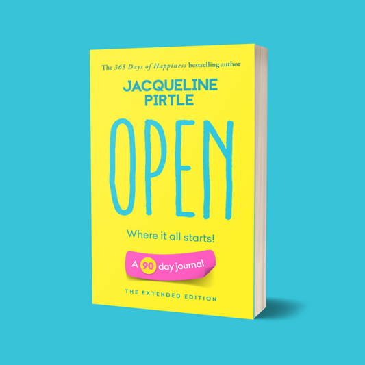 A bright yellow book with the title 'Open – Where It All Starts' by Jacqueline Pirtle on a blue background. The cover also features a pink badge with the text '90-day journal - extended edition' from the life-changing journal series.