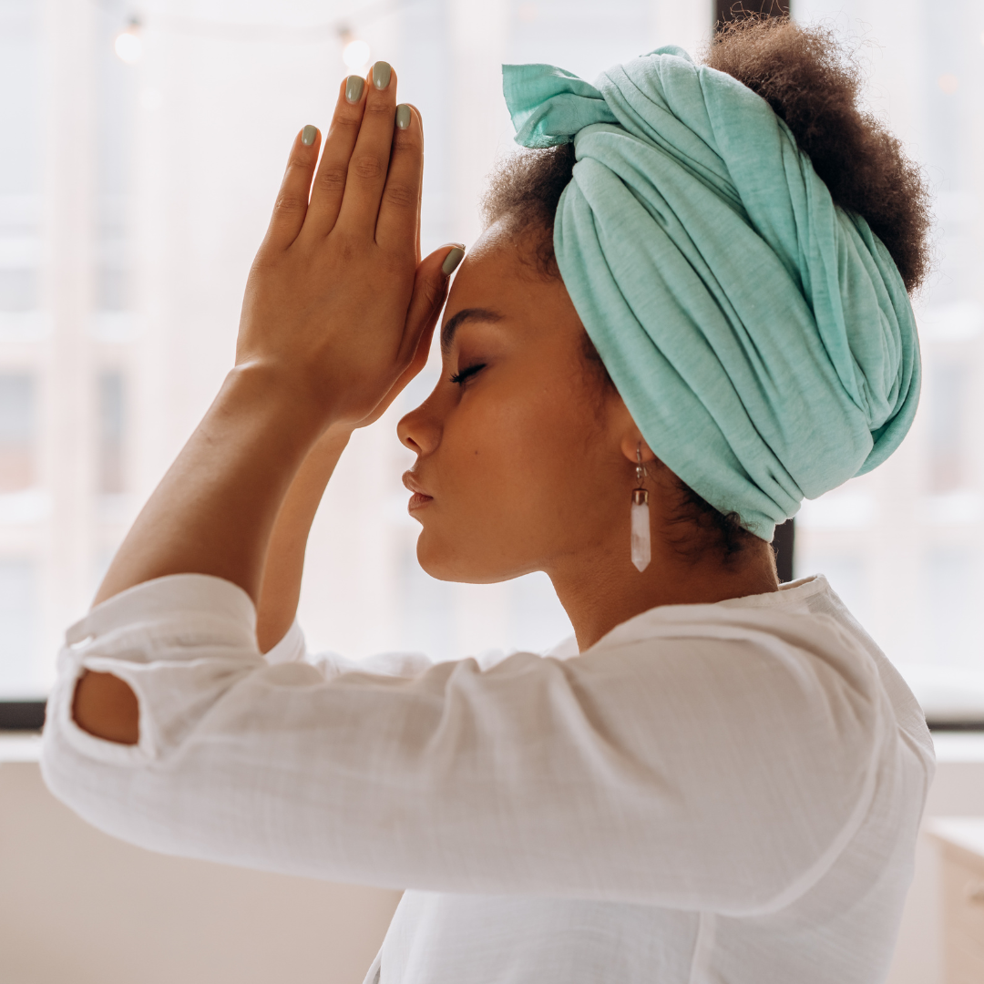 Woman with a green headscarf shielding her eyes from the sun. She is happy