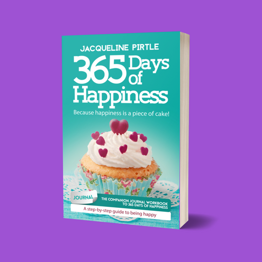 A paperback copy of '365 Days of Happiness' the companion journal workbook by Jacqueline Pirtle, featuring a cupcake with hearts on the frosting on a green-blue background.